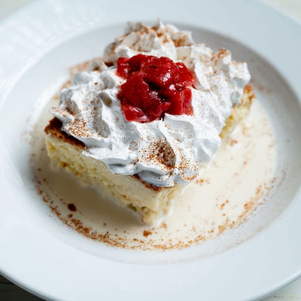 Taco City DC's tres leches cake with whipped cream, cinnamon, and cherry topping.
